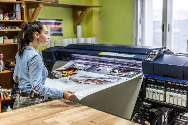 A woman manually checks the quality of a cmyk offset printer. A woman manually checks the quality of a cmyk offset printer.