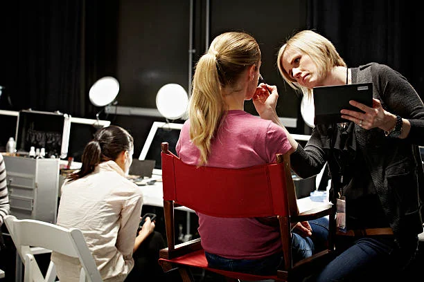 Make-up artist applying make-up to female model backstage at fashion show Make-up artist applying make-up to female model backstage at fashion show